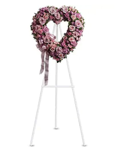 Heart-shaped pink rose wreath on a standing easel with ribbon