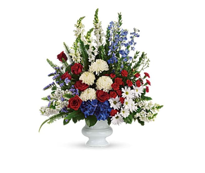 Mixed red, white, and blue flowers arranged in a white vase