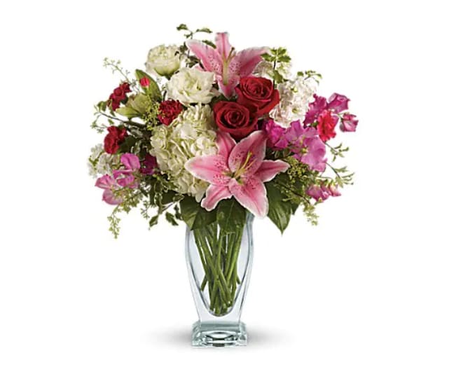 Pink lilies and red roses in a clear glass vase
