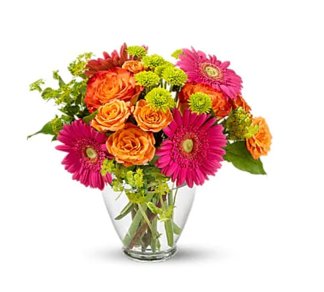 Bouquet of orange roses and pink gerbera daisies in a clear glass vase