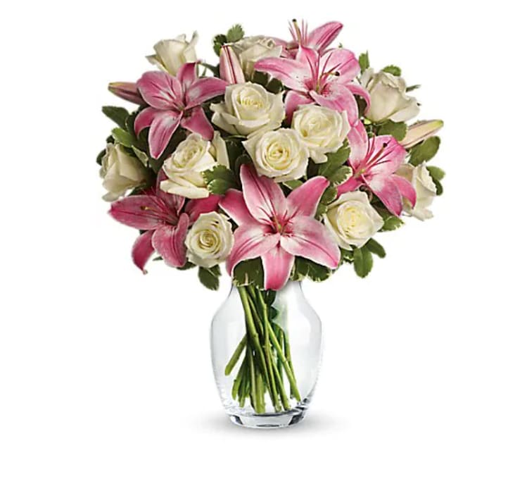 Pink lilies and white roses in a clear glass vase