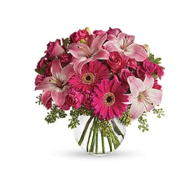 Little Pink Me Up - Youthful. Graceful. Beautiful. These are just a few qualities that come to mind when gazing at a gorgeous bouquet of pink flowers. Whether you want this arrangement to say "Happy Anniversary" or "Happy Any Day," you can be sure the day it arrives will be brighter for anyone lucky enough to receive it. Lovely pink roses and asiatic lilies are joined by hot pink gerberas and miniature carnations, pink full-sized carnations and more in a clear glass ball. Send this one and life will be a bowl of cheer! 