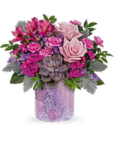 Lovely Shine Bouquet - This sparkling gift takes Mother's Day glam to a whole new level! Playful pink and lavender blooms are arranged with a desert-inspired succulent in a sparkling mosaic glass vase. This chic bouquet features light pink roses, purple alstroemeria, miniature lavender carnations, dark pink sweet william, lavender sinuata statice, dusty miller, huckleberry and a large green echeveria succulent plant. Delivered in a Shining Beauty cylinder. 