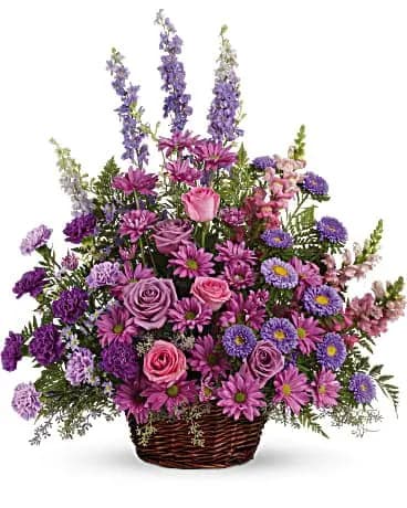 Gracious Lavender Basket - Soothing lavender, respectful purple and compassionate pinks are combined beautifully in this basket overflowing with pretty flowers, sincerity and sympathy. A lovely way to share your thoughts and pay tribute to someone special. A profusion of purple, pink and lavender blooms such as roses, carnations, larkspur, matsumoto and monte cassino asters and much more are delivered in a round wicker basket. 