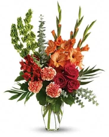 Days of Sunshine Bouquet - Red roses, red alstroemeria and orange gladioli in a sparkling Ming urn - a lovely tribute that sends a message of hope and healing for those mourning their loss. The brilliant arrangement includes red roses, red alstroemeria, orange gladioli, orange carnations and bells of Ireland, accented with assorted greenery. Delivered in a clear glass Ming urn. 