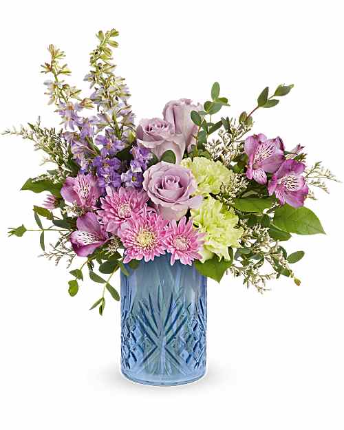 Garden Whimsy Bouquet  - Surprise Mom with a Garden Whimsy Bouquet, a soft blend of lavender and pink blooms beautifully arranged in Blue Belle Vase. This elegant Mother's Day gift adds fresh spring charm and lasting beauty to any space. Garden Whimsy Bouquet is a charming Mother's Day flower arrangement featuring lavender roses, purple alstroemeria, green carnations, lavender larkspur, lavender cushion spray chrysanthemums, and white limonium, accented with lemon leaf and parvifolia eucalyptus.   Approximately 15" W x 15 1/2" H