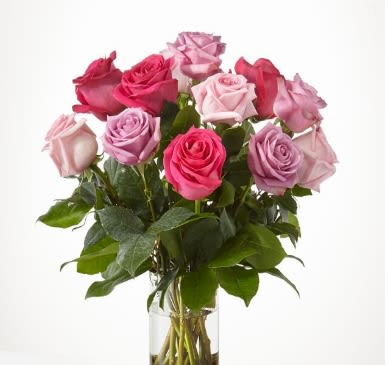 Bouquet of pink and lavender roses in a clear glass vase