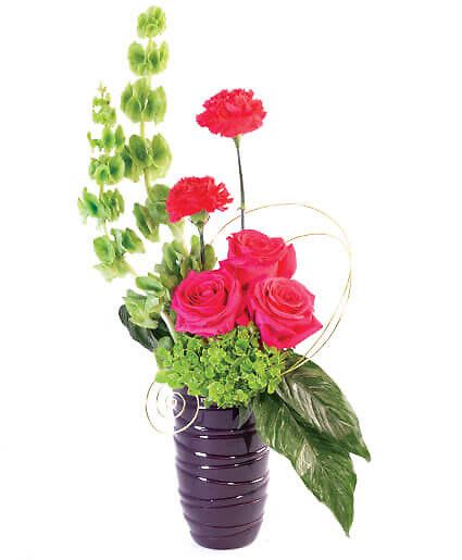 Pinks Of Passion - Sending the perfect symbol of devotion is easy with Pinks of Passion. Spectacular pink roses, carnations, and Bells of Ireland paint a picture of love that is out of this world!  Includes Purple Ceramic Vase, Decorative Floral Wire, Greens: Aspidistra Leaves, Flowers: Hot Pink Roses, Hot Pink Carnations, Bells Of Ireland, Green Hydrangea.