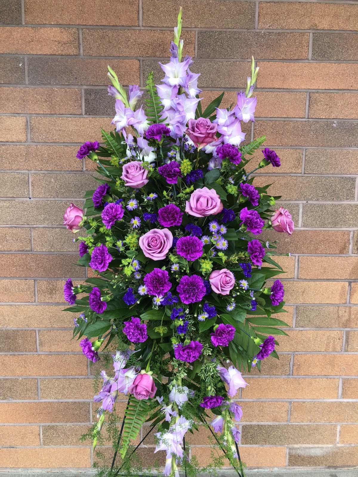 Standing floral spray with purple roses and lilies