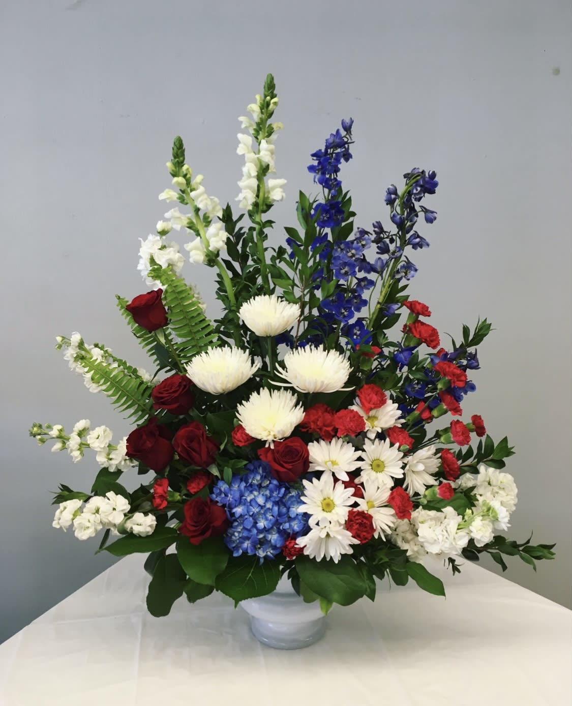 Mixed bouquet in a white vase with red, white, and blue flowers