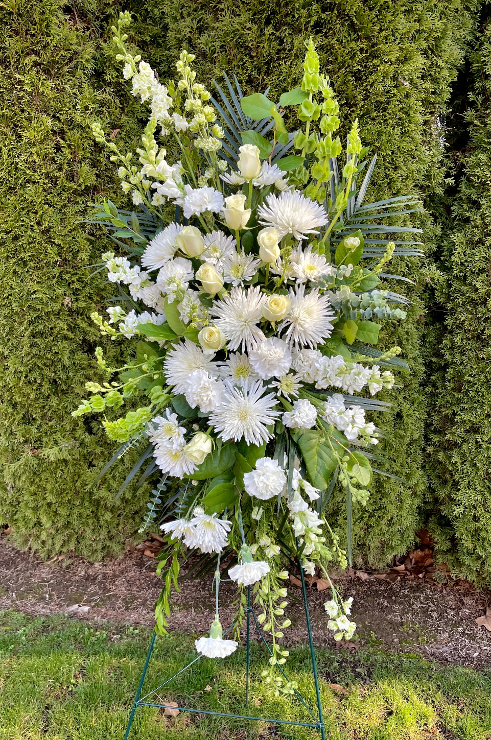 Tall white floral standing spray on a metal easel
