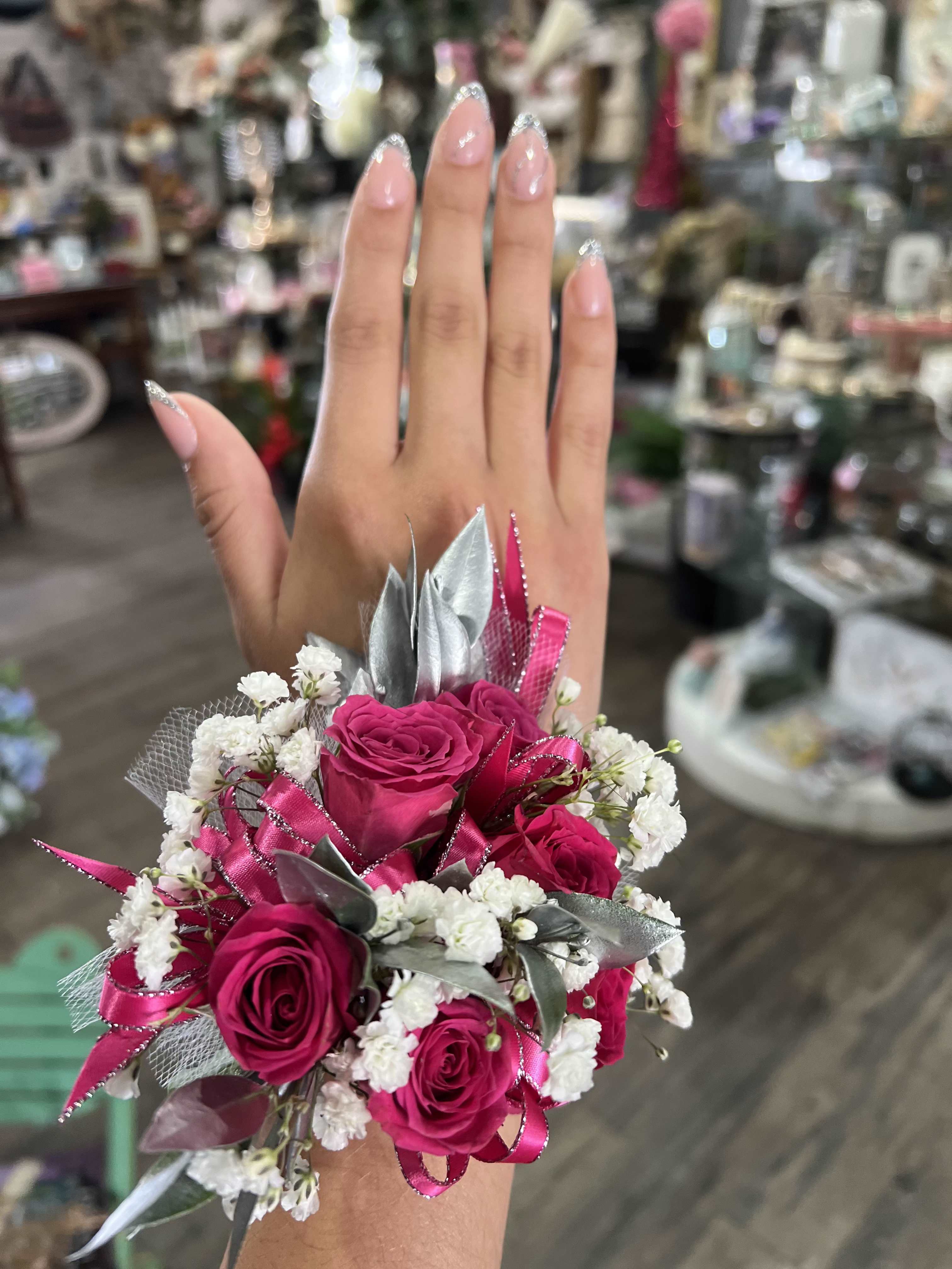 Pink rose wrist corsage with white filler flowers and silver ribbon
