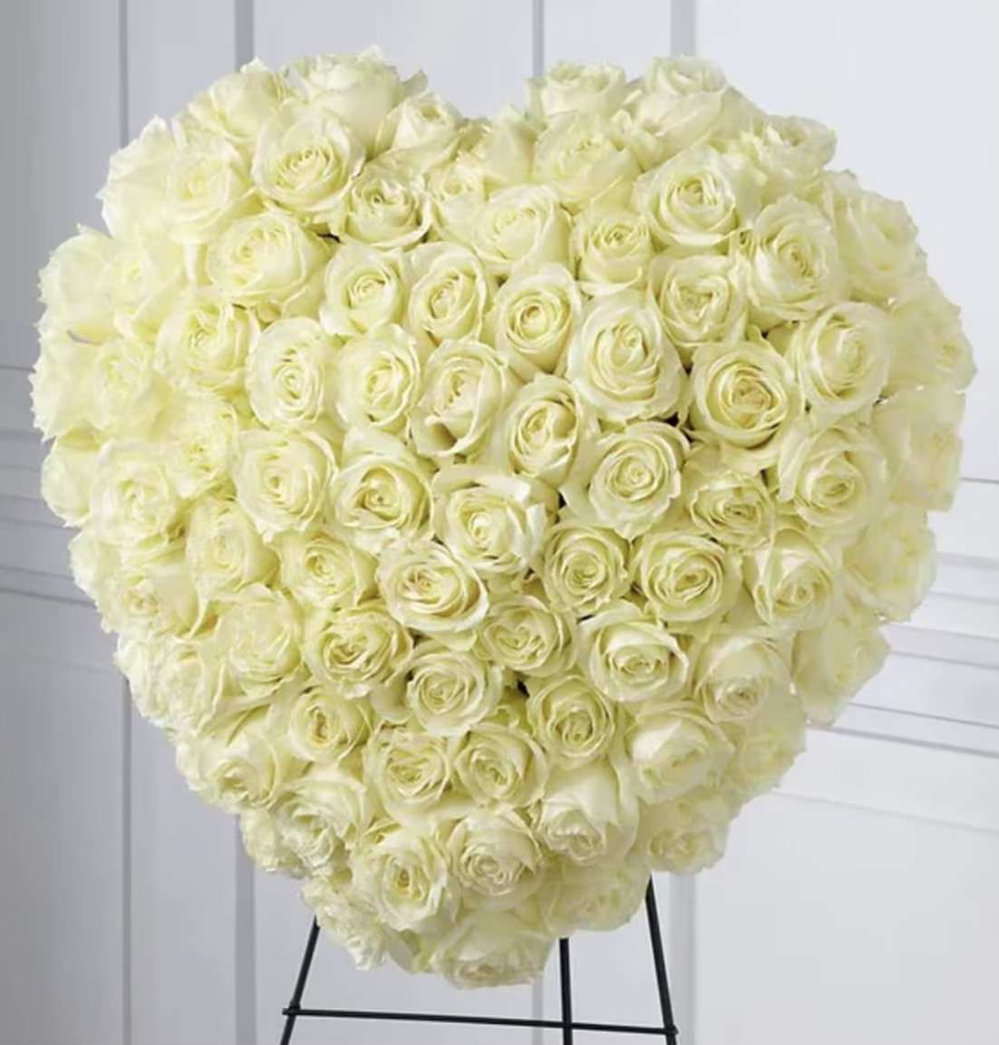 Large heart-shaped bouquet of cream roses on a stand