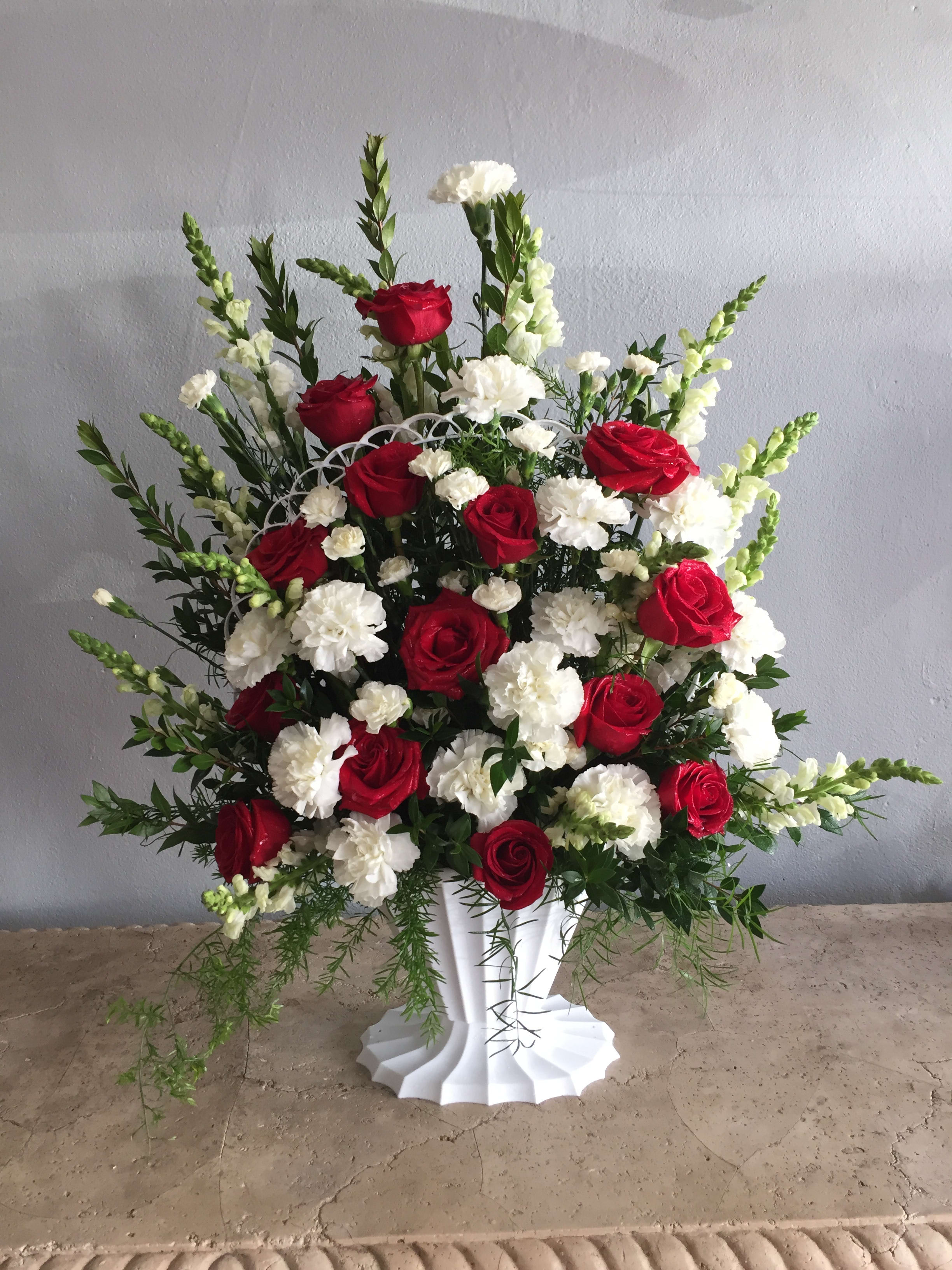 Red roses and white carnations in a white vase