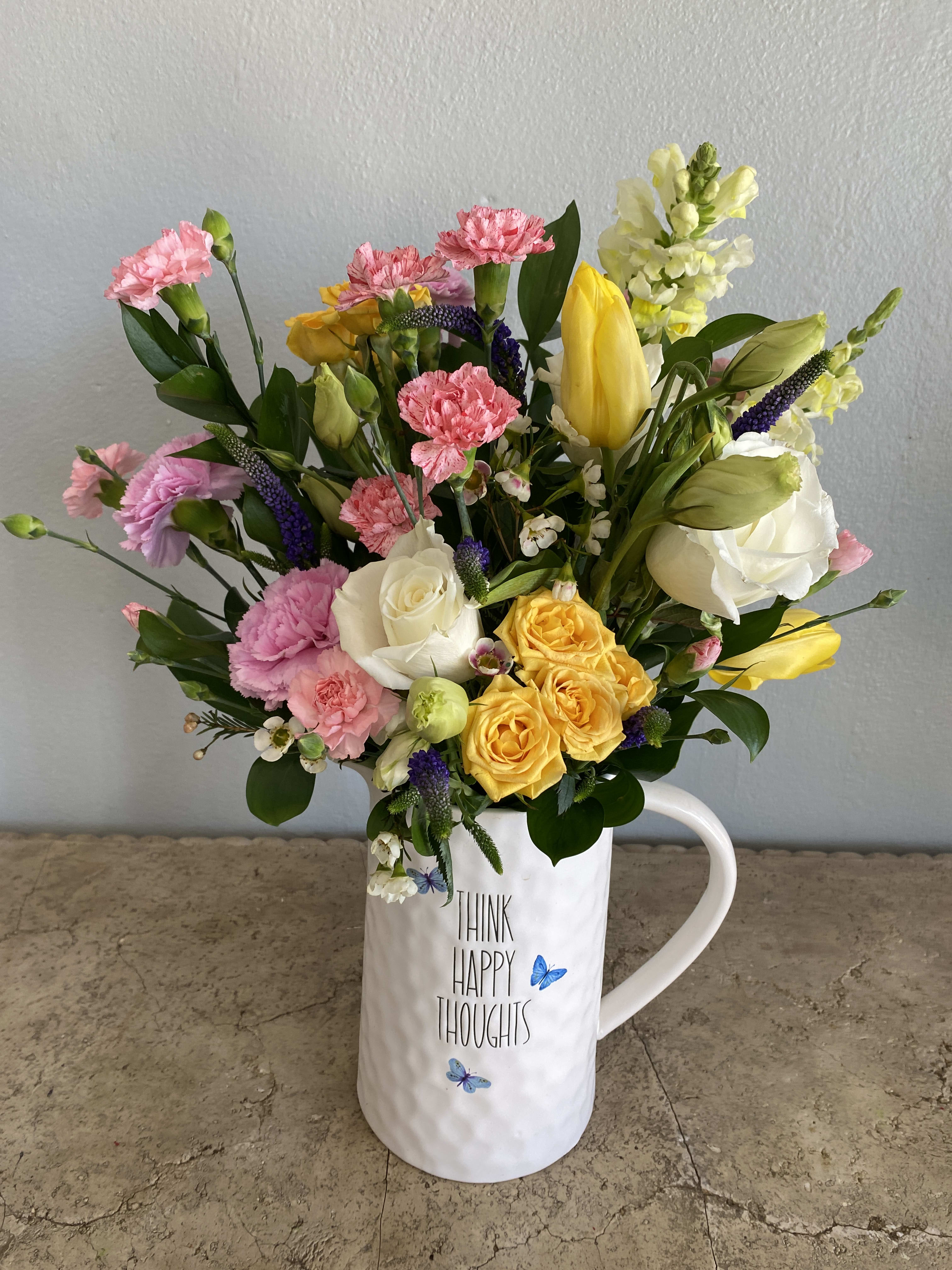 Mixed bouquet in a white mug with pink, yellow, and white flowers