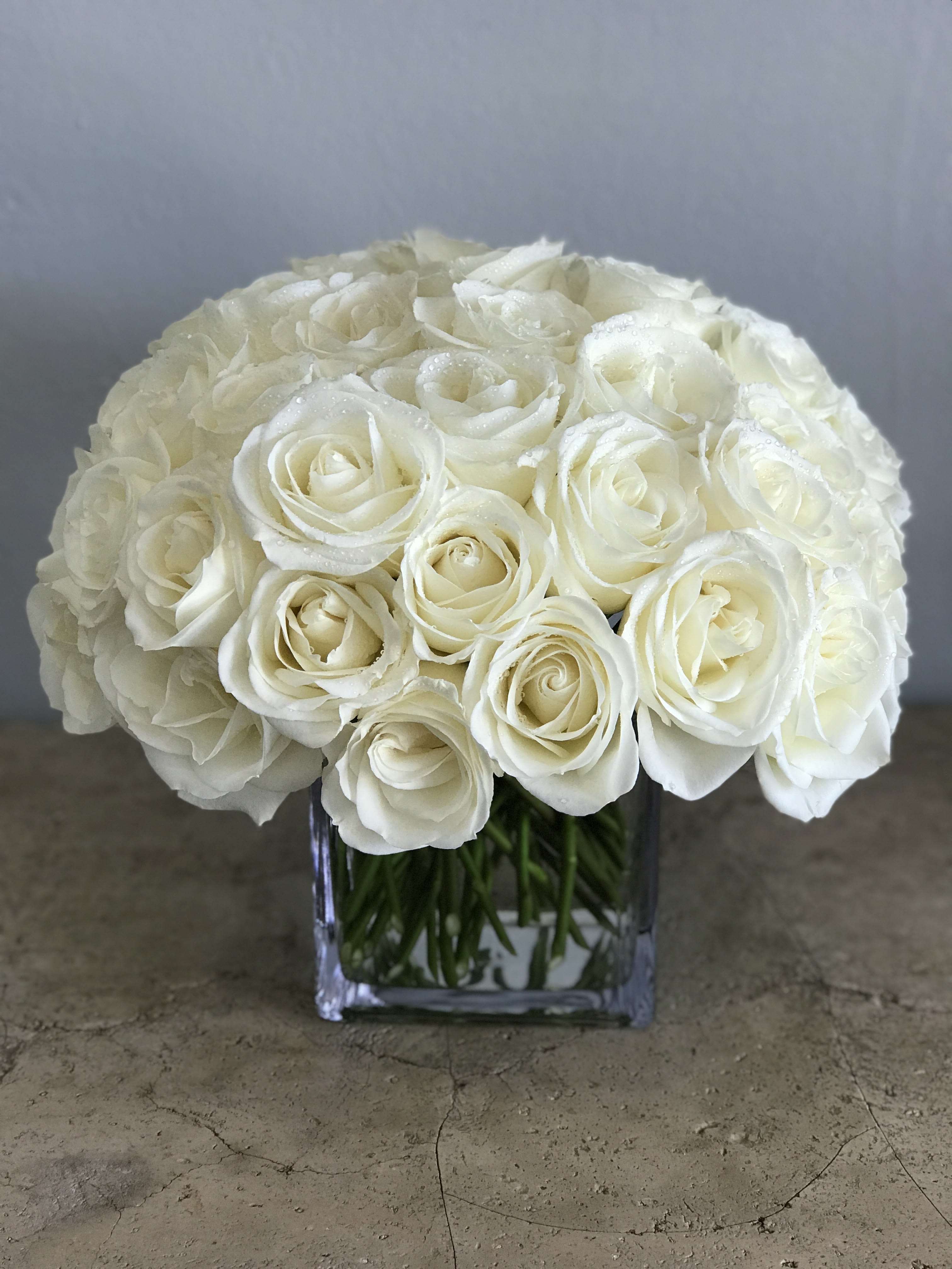 White rose bouquet in a clear square vase