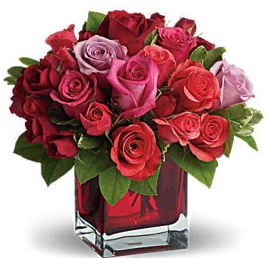 Bouquet of red and pink roses in a red glass vase