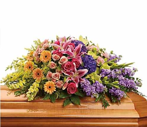 Colorful floral casket spray with lilies, roses, and daisies