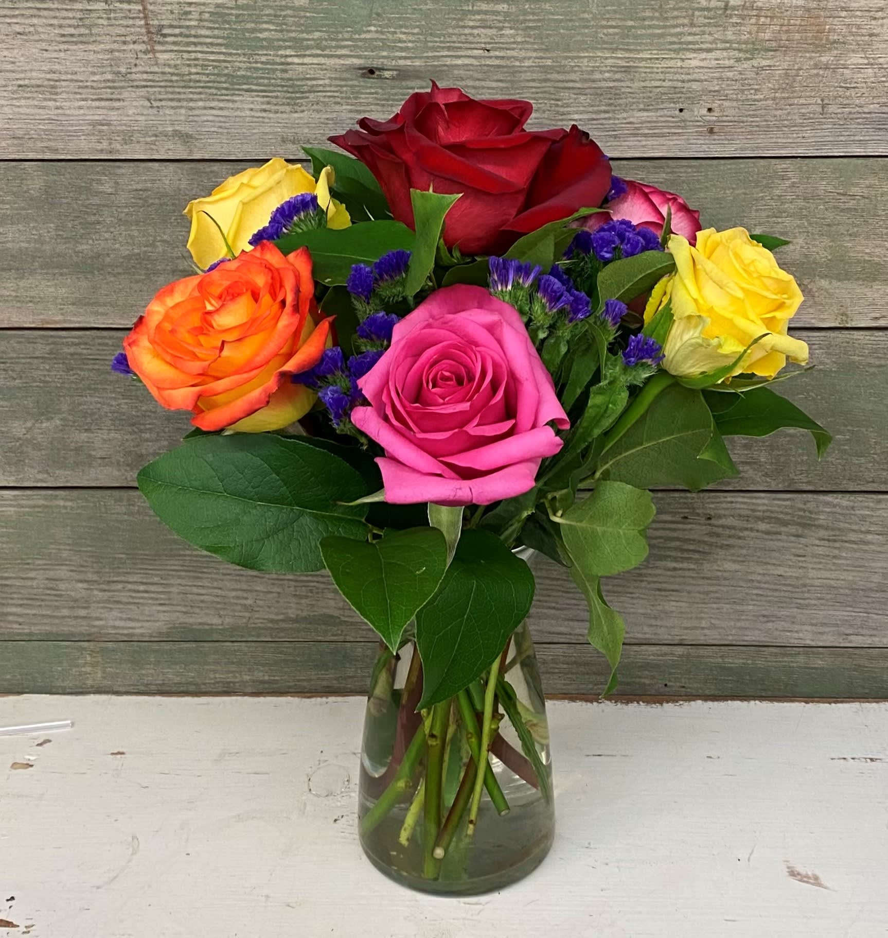Colorful roses arranged in a clear glass vase