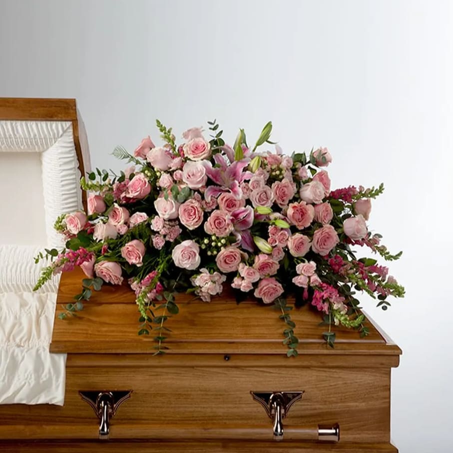 Tender Heart by BloomNation™  - Roses, lilies, and more come together for a blushing pink half casket spray. Sized to fit both open and closed caskets. 