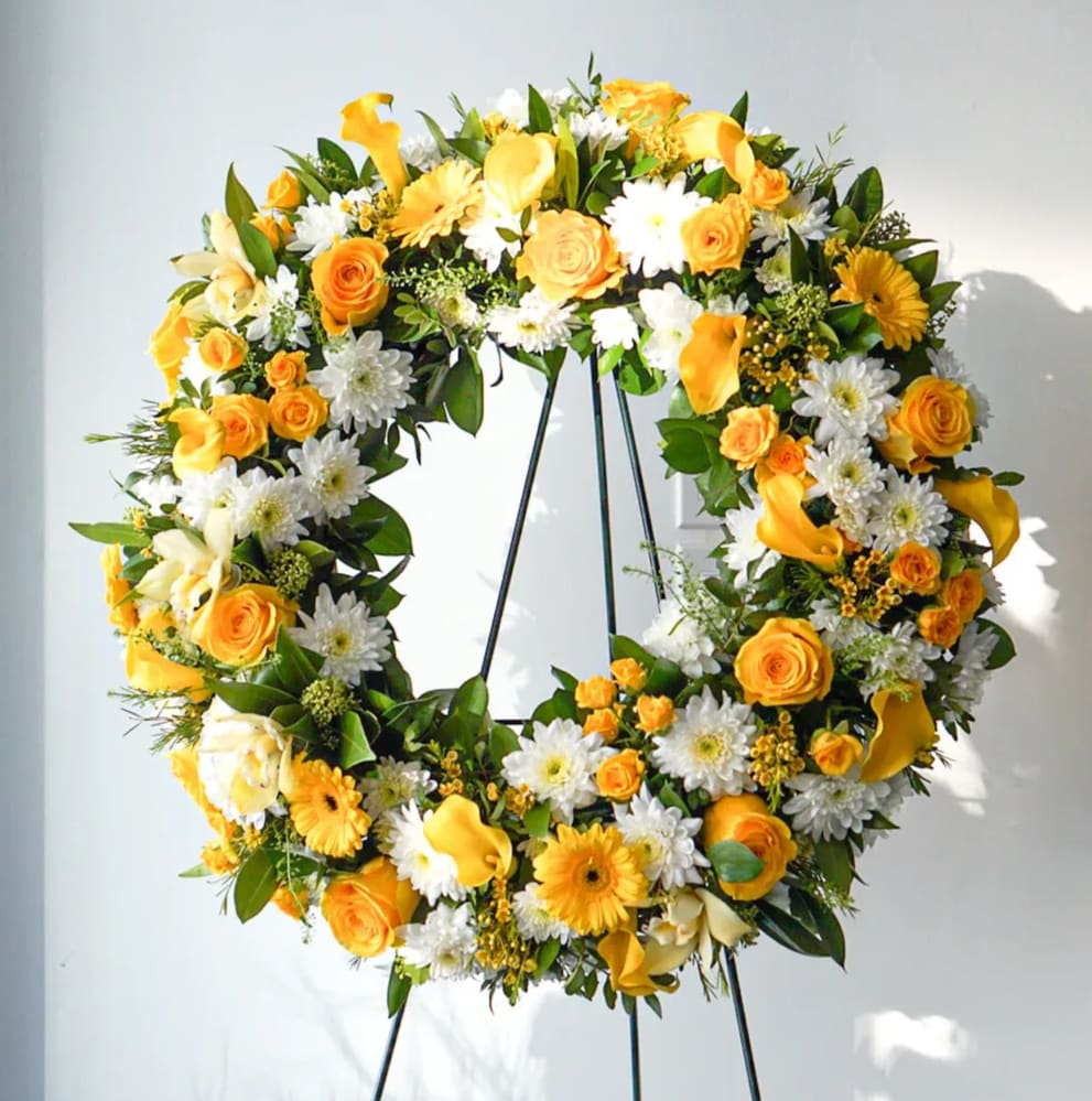 Yellow and white floral wreath on a black stand