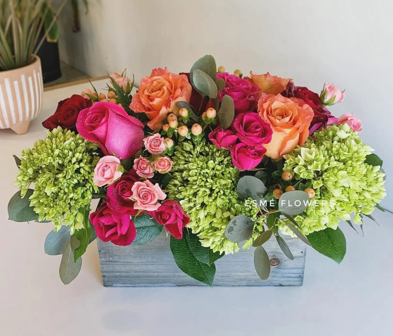 Mixed roses and green hydrangeas in a wooden box