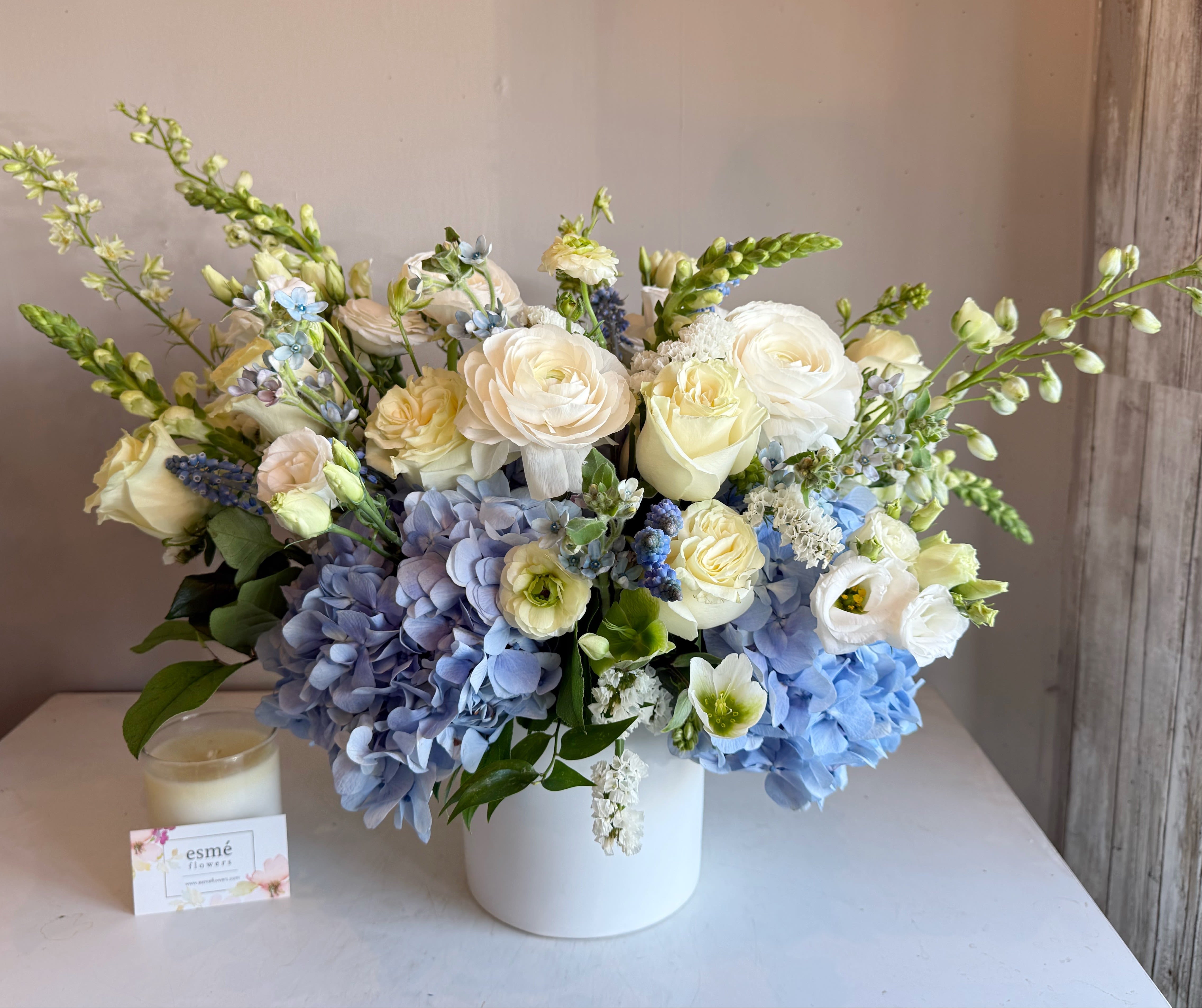 Blue and white floral arrangement in a white vase