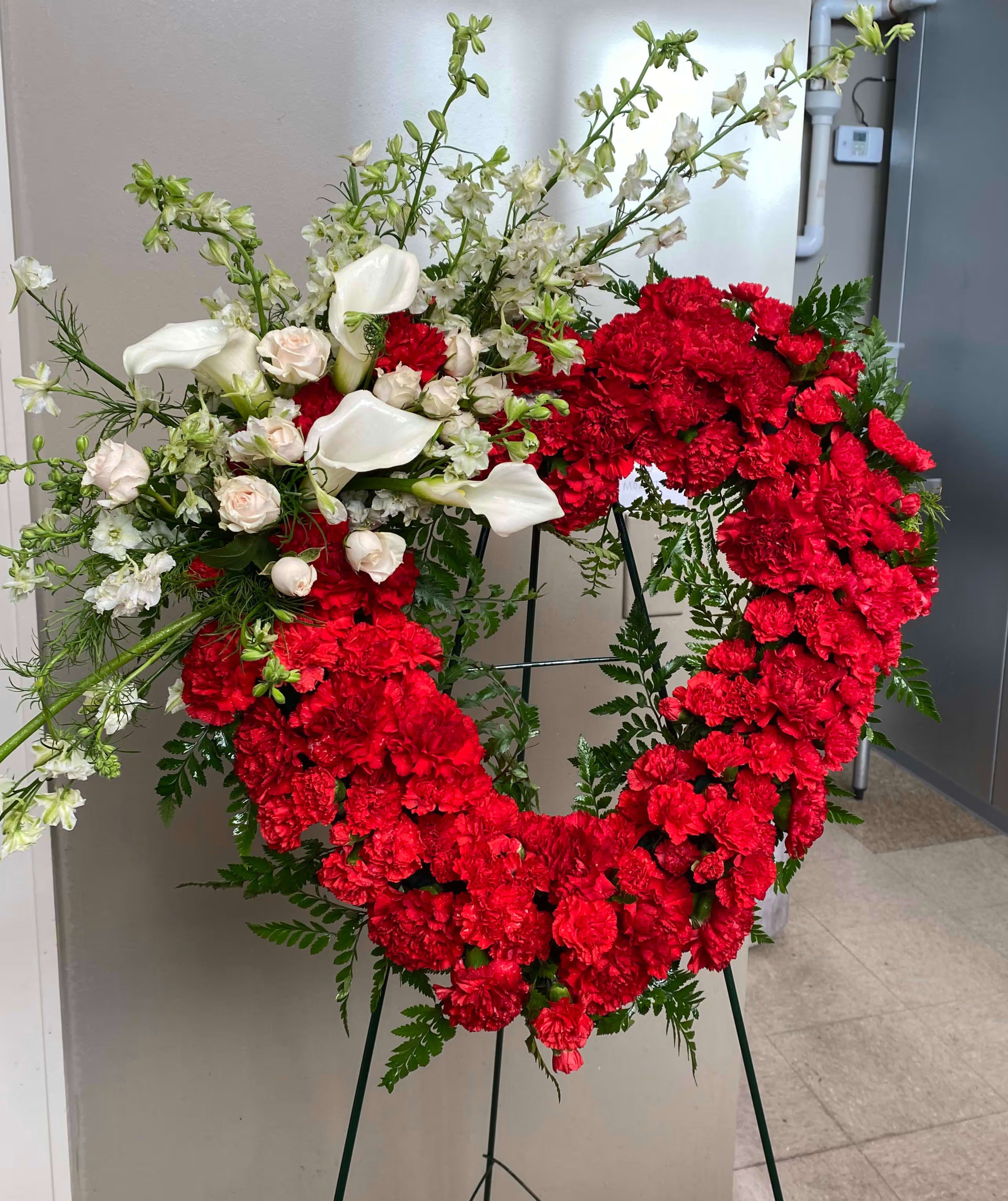 Heart-shaped red carnation wreath with white calla lilies and roses