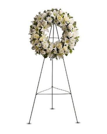 White floral funeral wreath on a metal easel