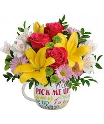 Bouquet of red roses and yellow lilies in a printed mug