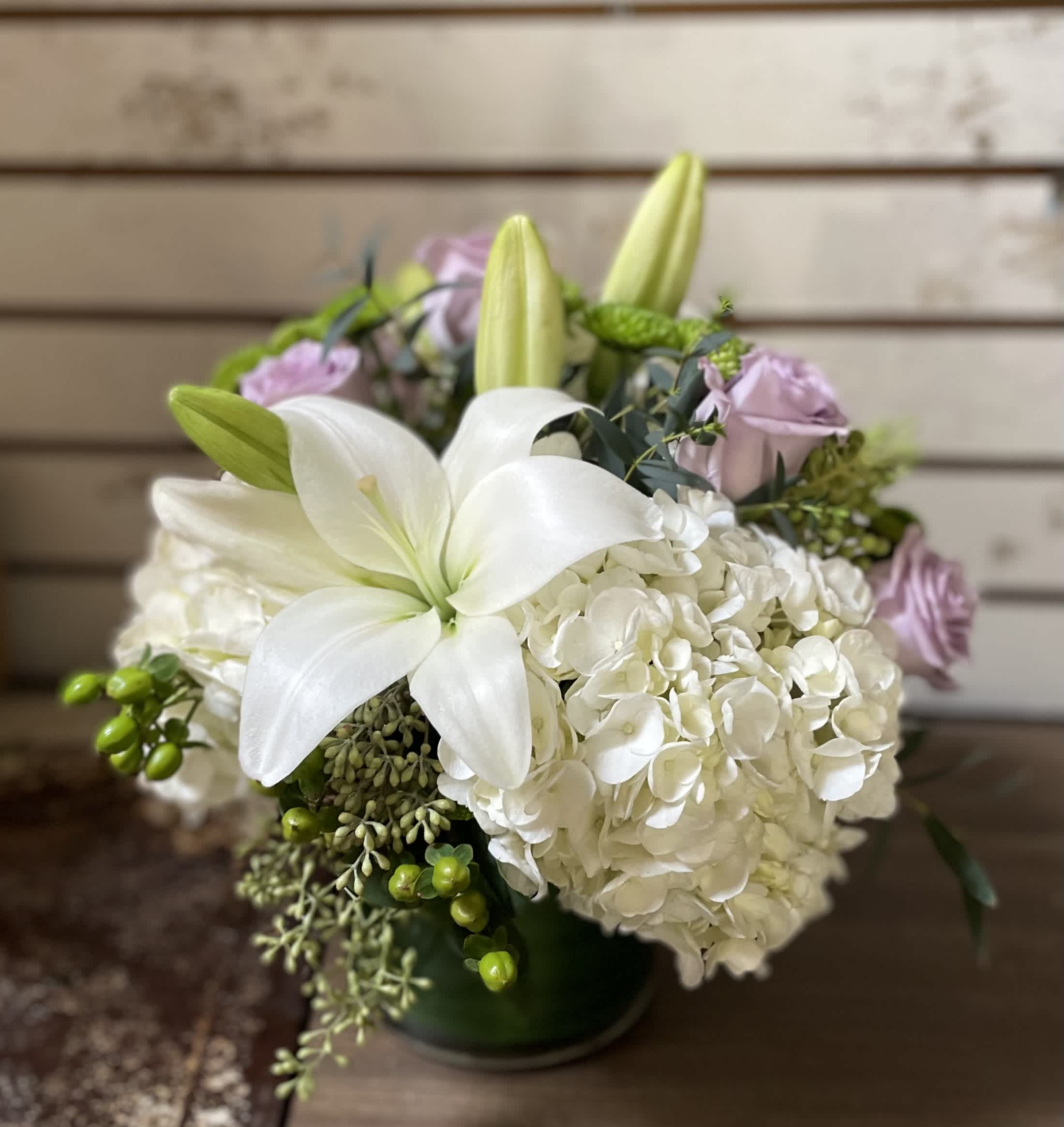 White lilies and hydrangeas with pale pink roses in a vase