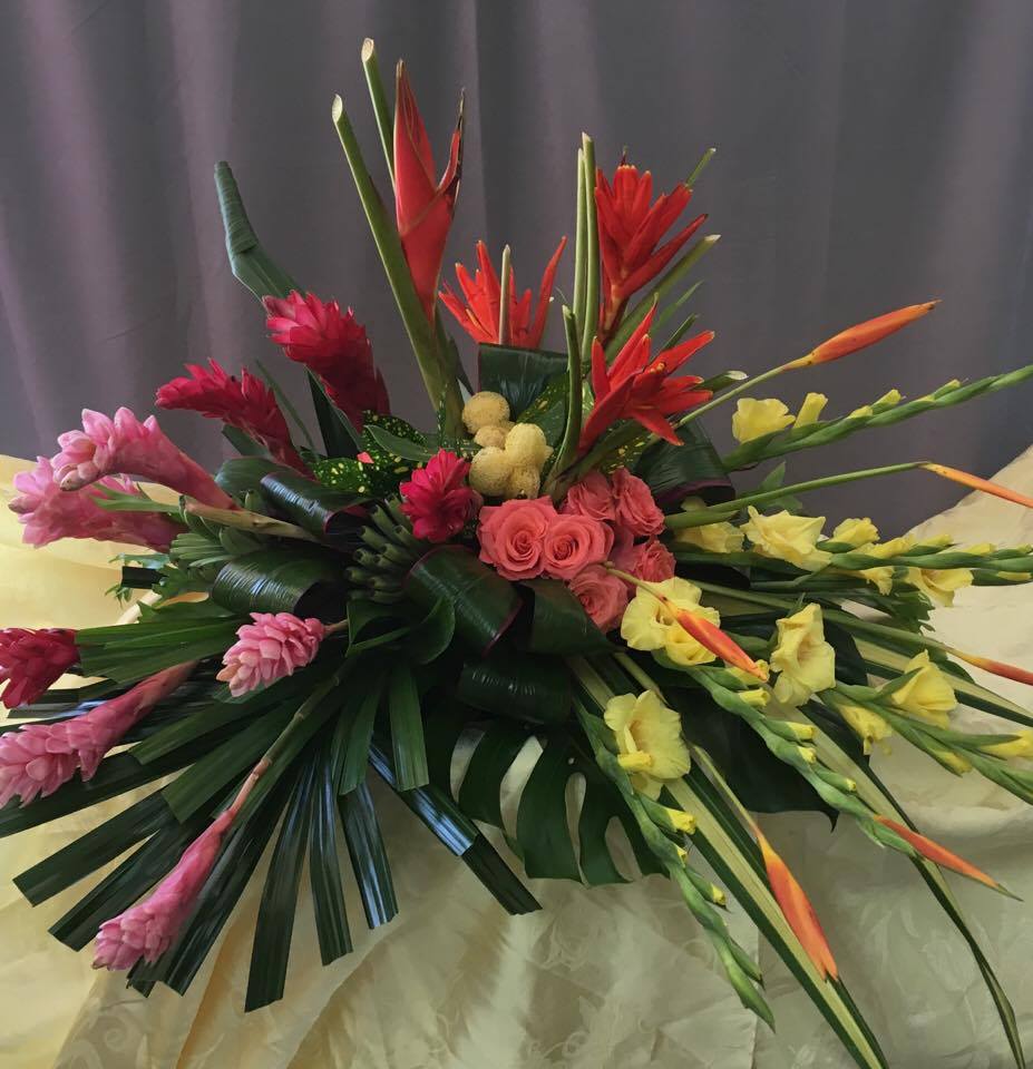 Tropical floral arrangement with pink, red, and yellow blooms