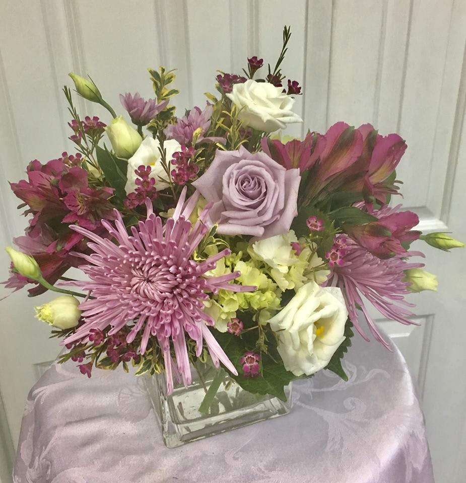 Bouquet of pink and white flowers in a square glass vase