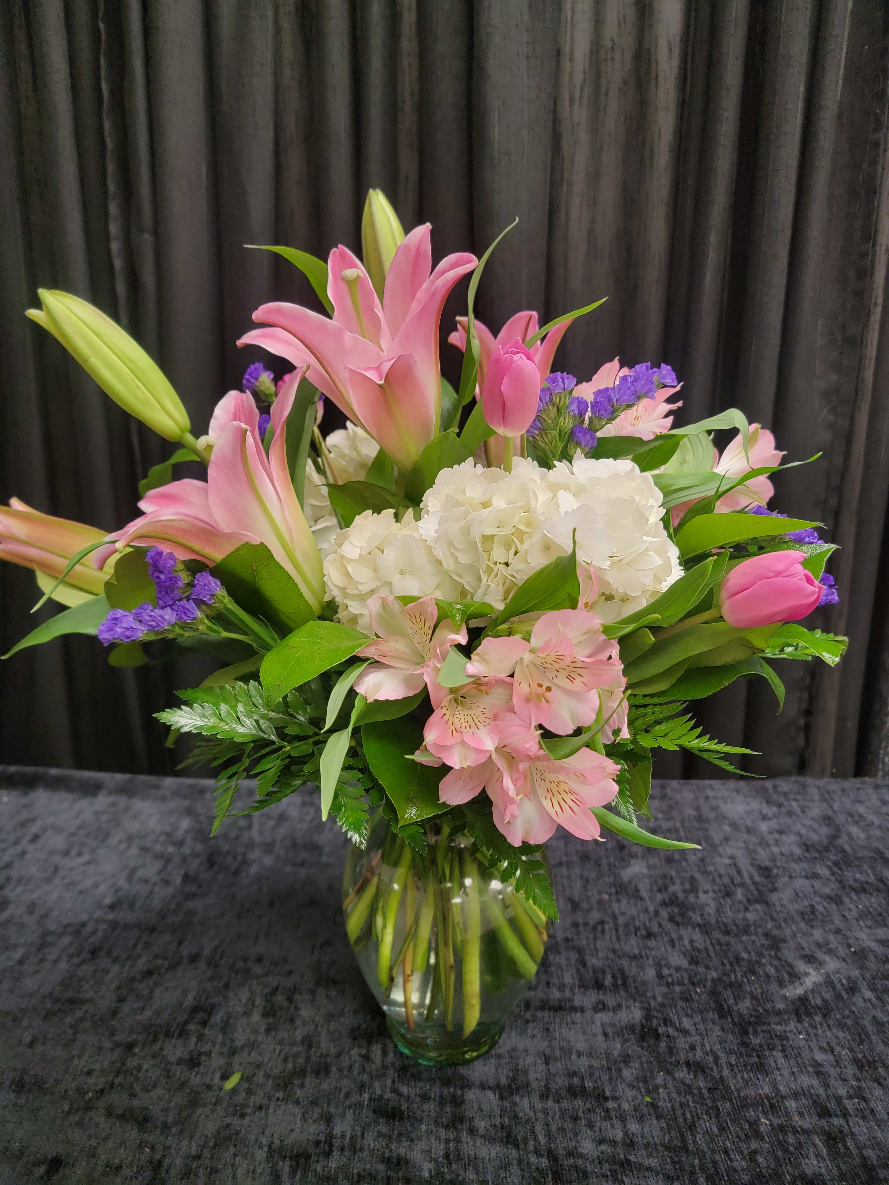 Mother's Love - A lovely vase of pink lilies, white hydrangea, alstromeria and tulips. Colors may slightly vary. 