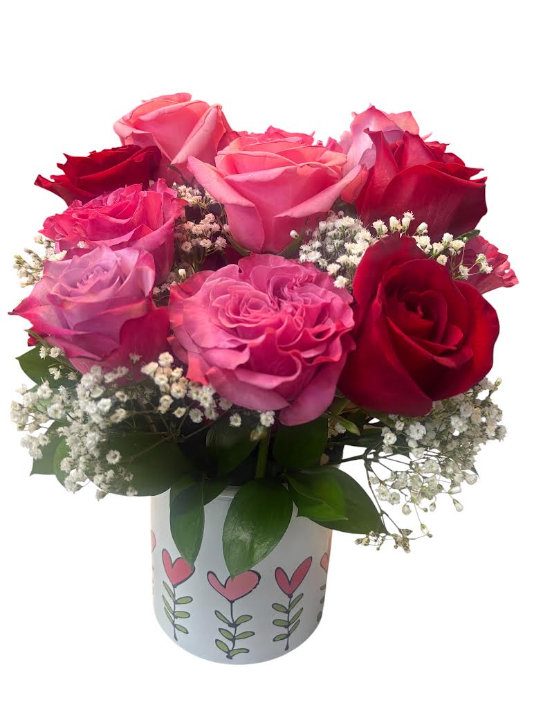 My Everything - A lush, tightly packed bouquet of Premium red, pink roses with delicate white filler flowers gives this flower arrangement a joyful, romantic presence-perfect as an anniversary roses arrangement, a Mother's Day gift, or a heartfelt "I'm sorry" gesture. The compact, rounded silhouette reads as love and celebration: she'll feel cherished the moment she sees the rich reds, soft pinks, and the crisp white accents working together.  The premium roses are arranged densely for a full, luxurious look and accented with small white baby's breath and glossy green leaves for contrast and texture. The flowers are presented in a light-colored printed with playful heart and simple plant motifs, adding a gift-like charm that suits birthdays, Valentine's Day, Christmas, or just-because surprises. Vase style and exact color may vary based on availability. 