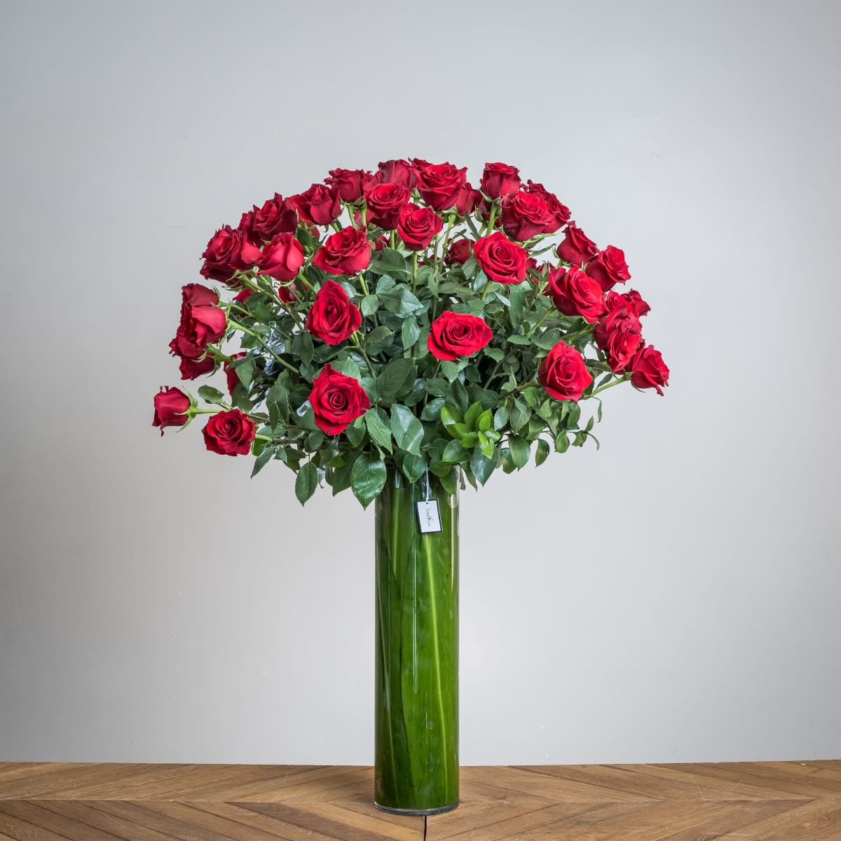 Roses of Luxury - 75 magnificent long-stem red roses are bursting out of a classic tall glass cylinder with an elegant leaf-lining. A truly show-stopping arrangement of all red roses is the ultimate gift of love to show that lucky someone how much you love them this Valentine's Day.   Measures approx. 45" H x 32" W