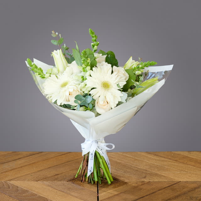 White Peace Wrap Bouquet  - This beautiful hand wrap bouquets is create of mix white florals with an elegant white paper giving a soft Angelic look. Perfect for any occasion. 