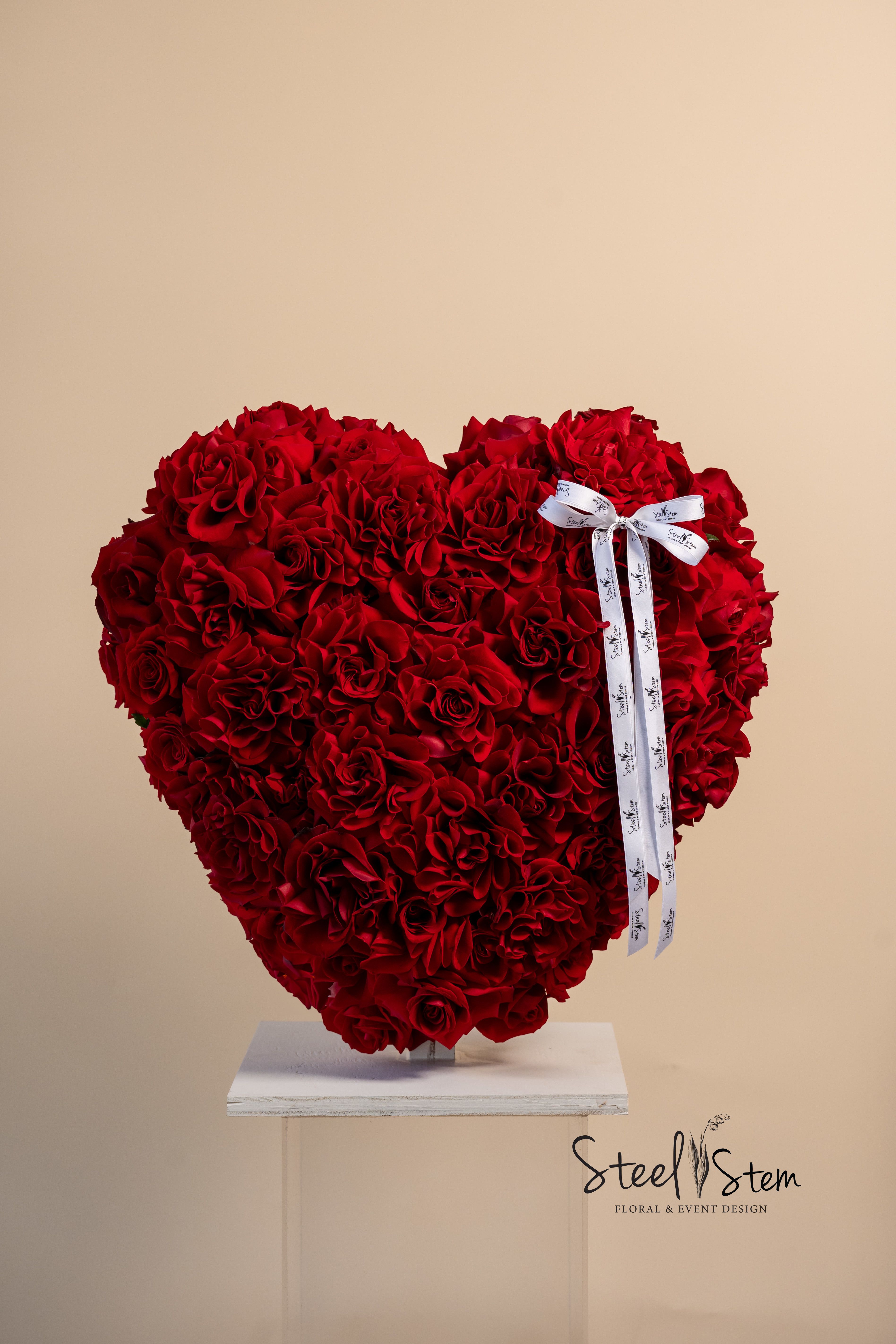 Heart of my heart - A breathtaking symbol of deep love and devotion, Heart of My Heart is the ultimate romantic gesture. Crafted with lush, velvety red roses in a striking heart shape, this 22”x22”arrangement speaks volumes without saying a word. Every petal represents passion, every bloom a promise, making it the perfect expression of love, admiration, and heartfelt connection. Finished with an elegant satin ribbon, this timeless design is ideal for Valentine’s Day, anniversaries, or any moment that calls for an unforgettable declaration of love.