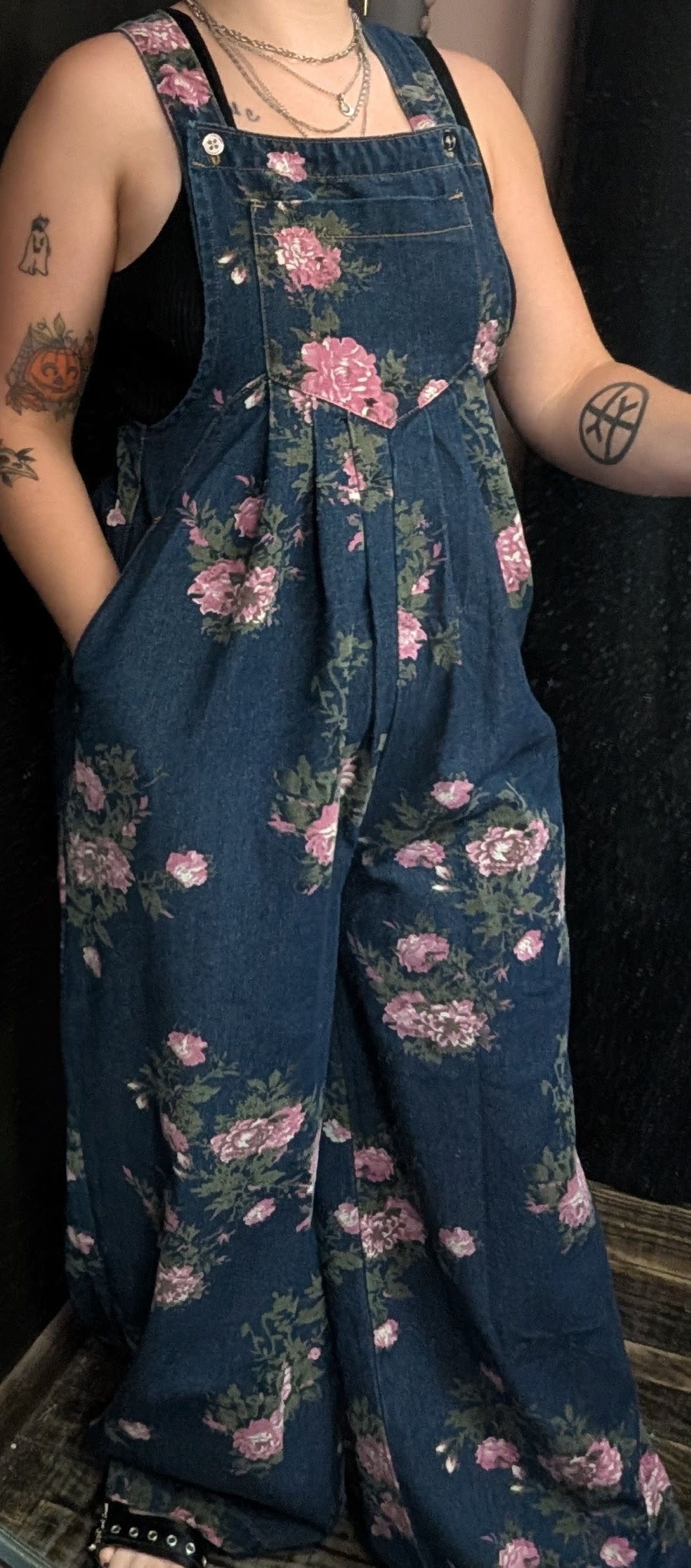 Dark Denim Floral Overalls - Oversized flare leg denim overalls with a front pouch, a back pocket, and pants pockets. Available in size S,M,L,XL.