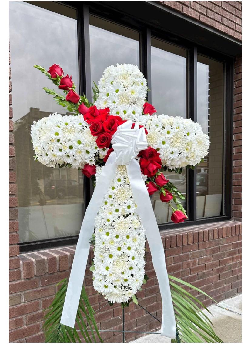 White floral cross with red roses and a white ribbon