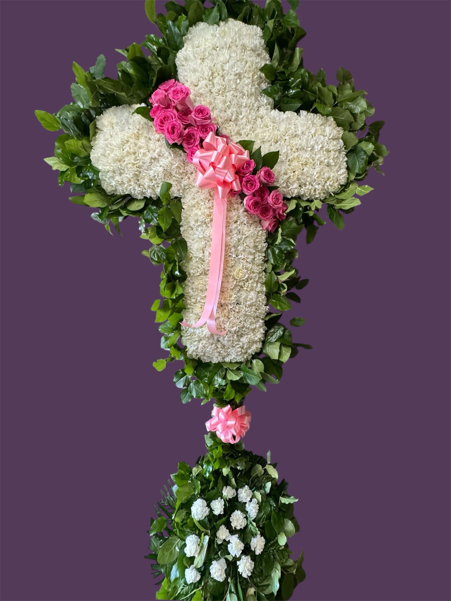 White floral cross with pink roses and ribbon on a purple background