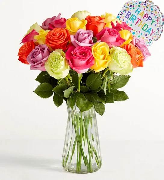 Colorful rose bouquet in a clear glass vase with a birthday balloon
