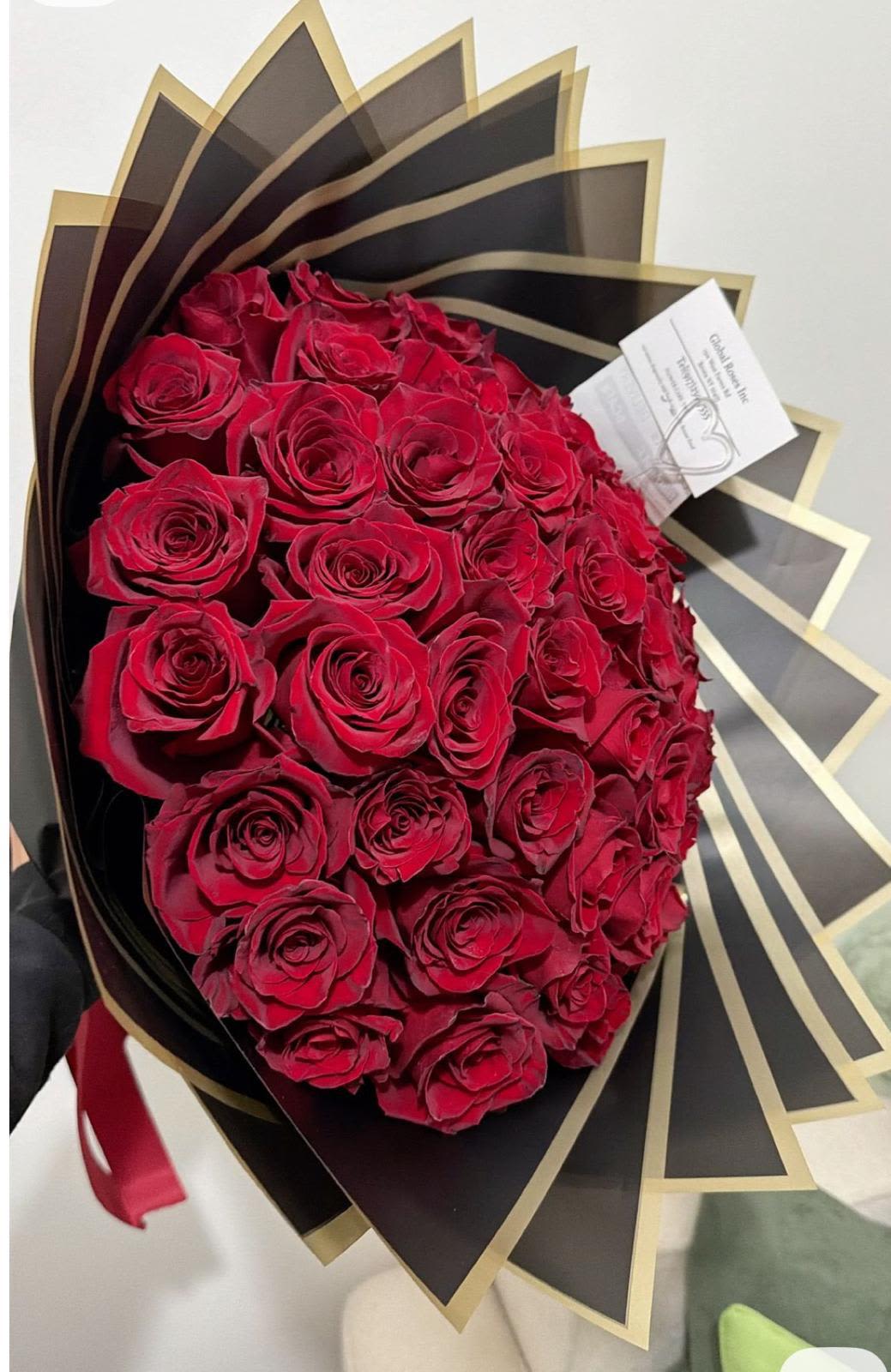 Bouquet of red roses wrapped in black and gold paper