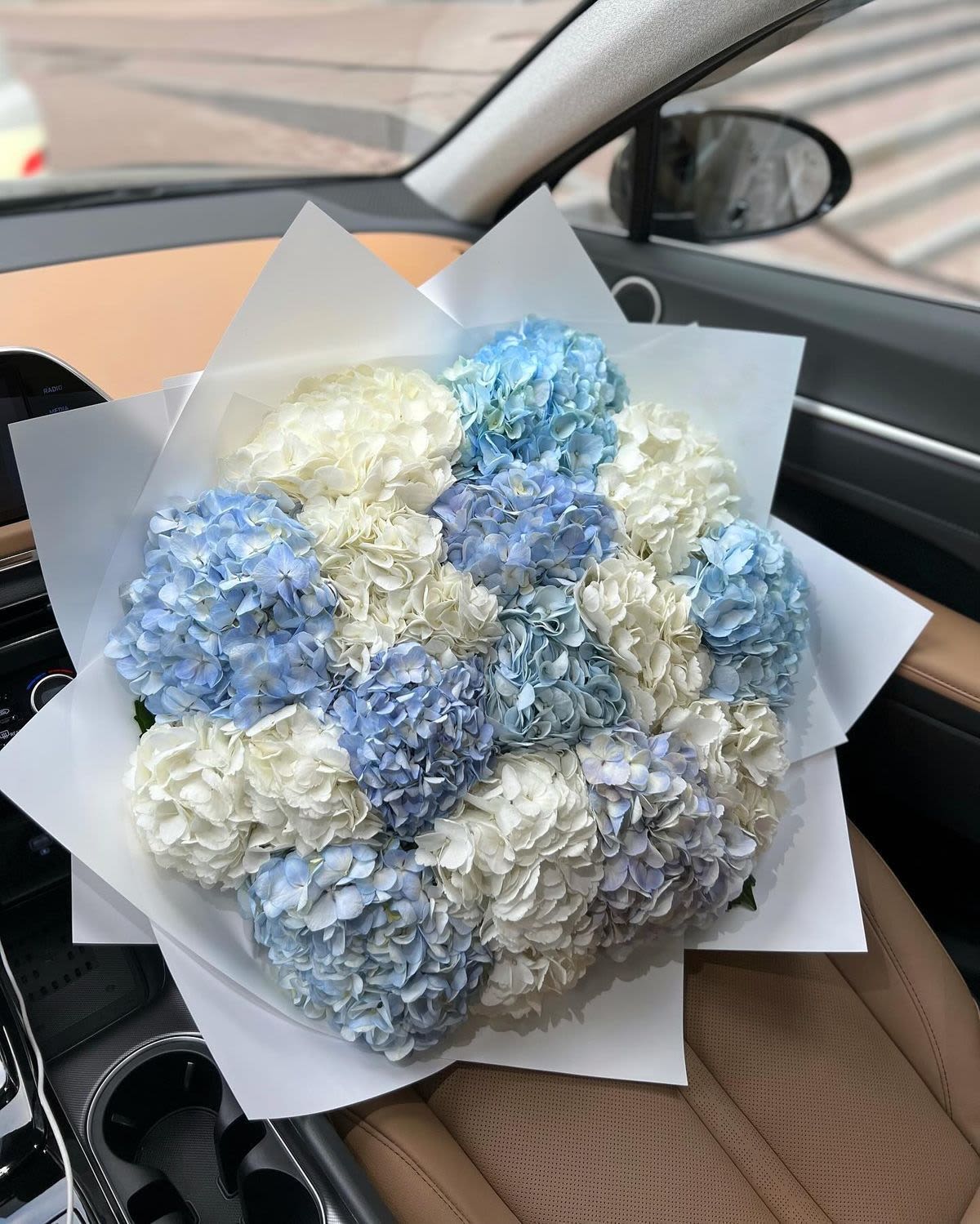 Bouquet of blue and white hydrangeas wrapped in white paper