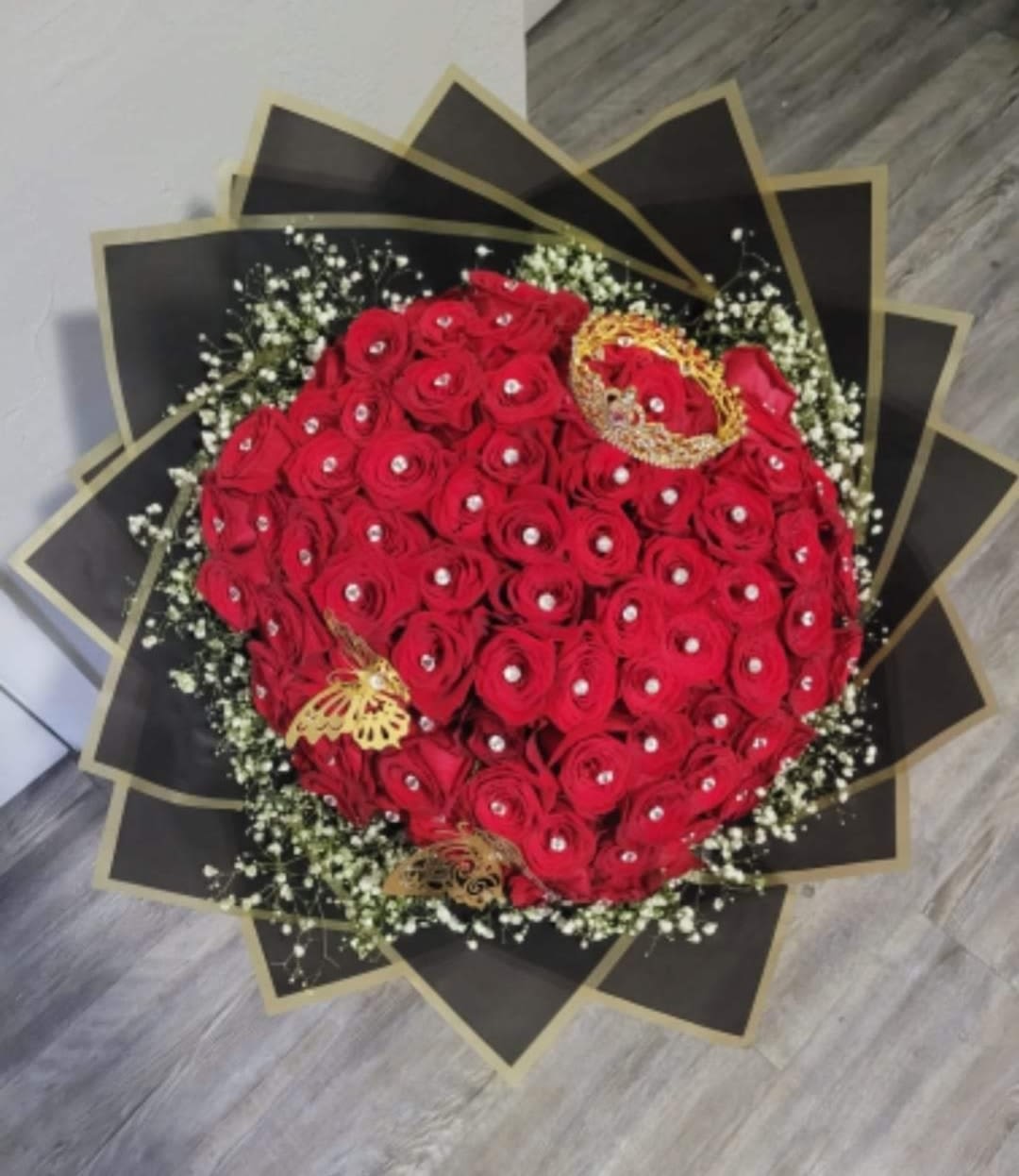 Bouquet of red roses with white filler and black-gold wrapping