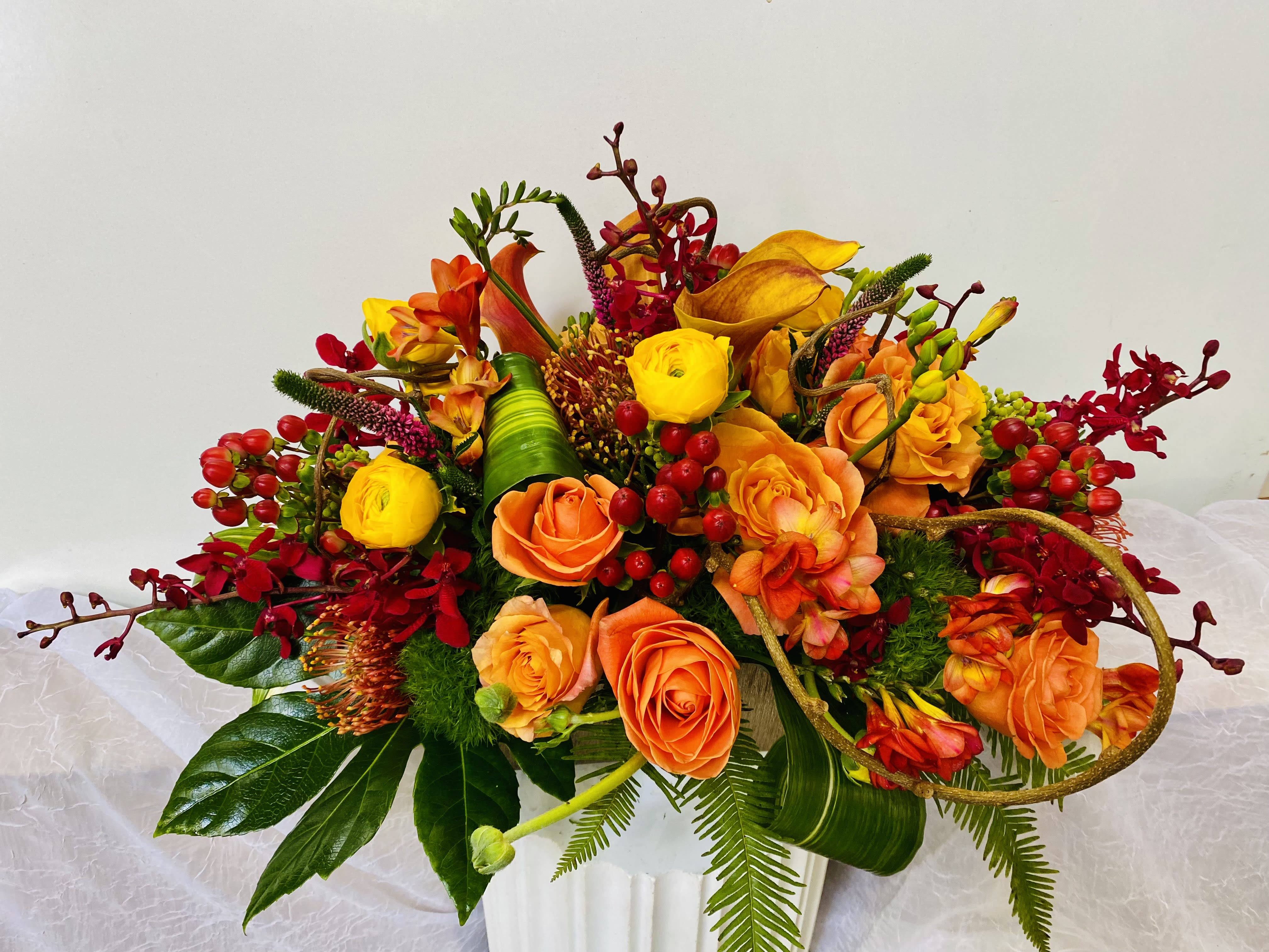Orange and yellow floral arrangement in a white vase