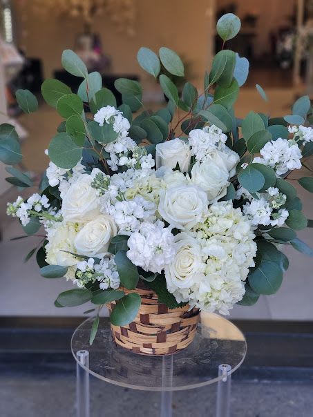 Fresh Air - Low woven basket of white roses and hydrangeas with eucalyptus accents for a fresh, elegant look