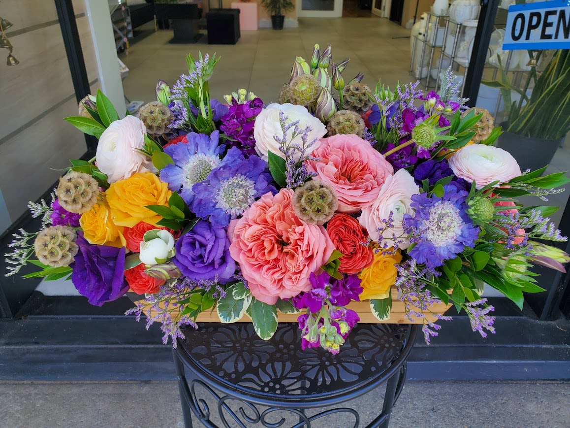 Fun Colors - Dense low centerpiece with mixed roses, ranunculus, scabiosa and textured accents in pinks, purples, yellow.