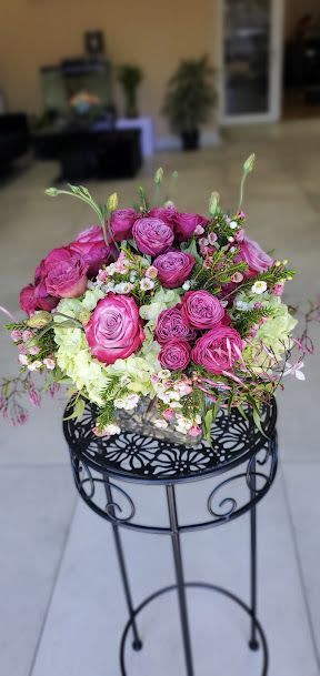 Hot is Hot - Hot pink roses with pale green hydrangeas, white accents, arranged in clear cube vase.