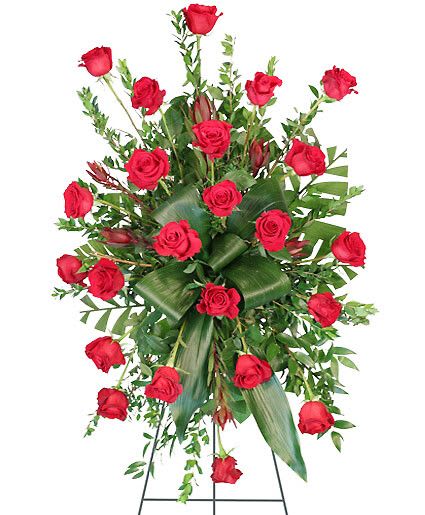 Crimson Departure - Send your loved one off with a truly classic standing spray filled with stunning red roses surrounding luscious foliage. The Crimson Departure standing spray is an elegant addition to any funeral service, memorial service, or wake.  Includes Easel, Large Wet Floral Foam Cage, Foliage: Myrtle, Aspidistra, Teepee, Salal, Red Roses, Safari Sunset Leucadendron.